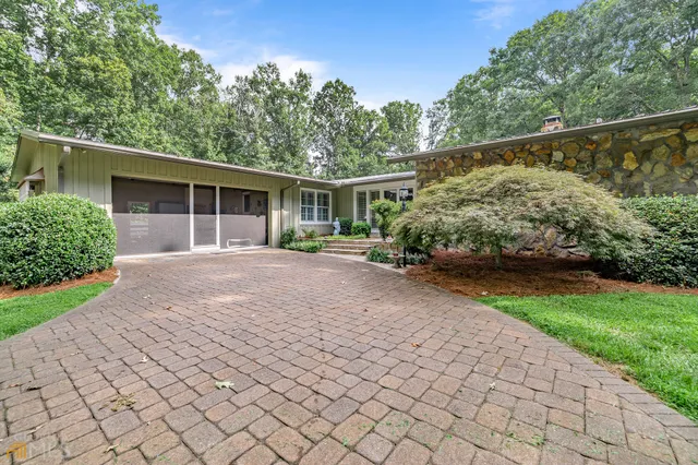 a front view of a house with a yard and potted plants