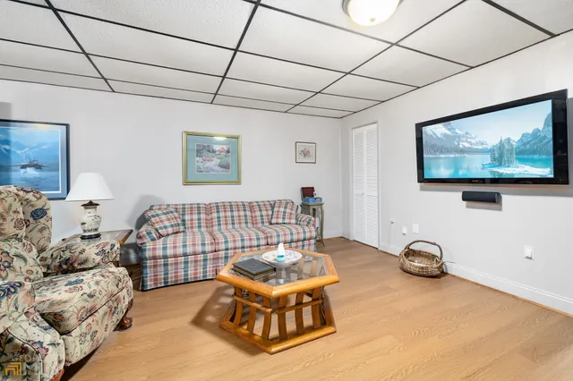 a view of a park with a large trees with wooden fence