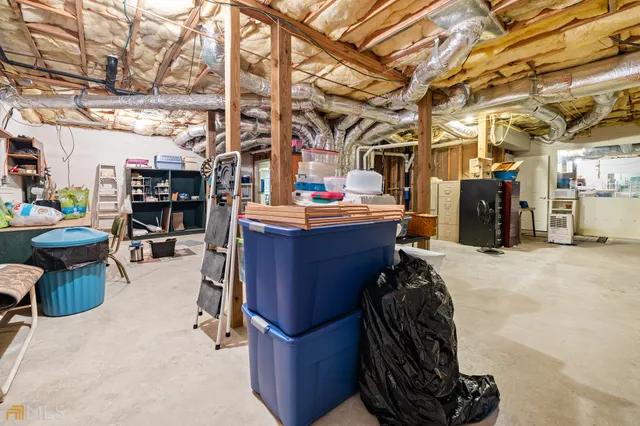 an aerial view of a house with yard and trees in the background