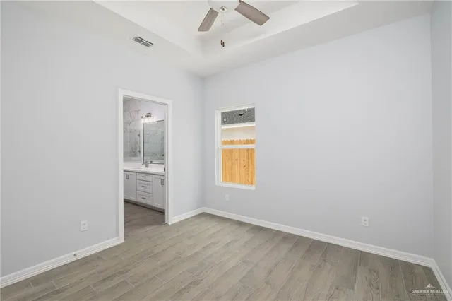 a view of an empty room with closet and a window