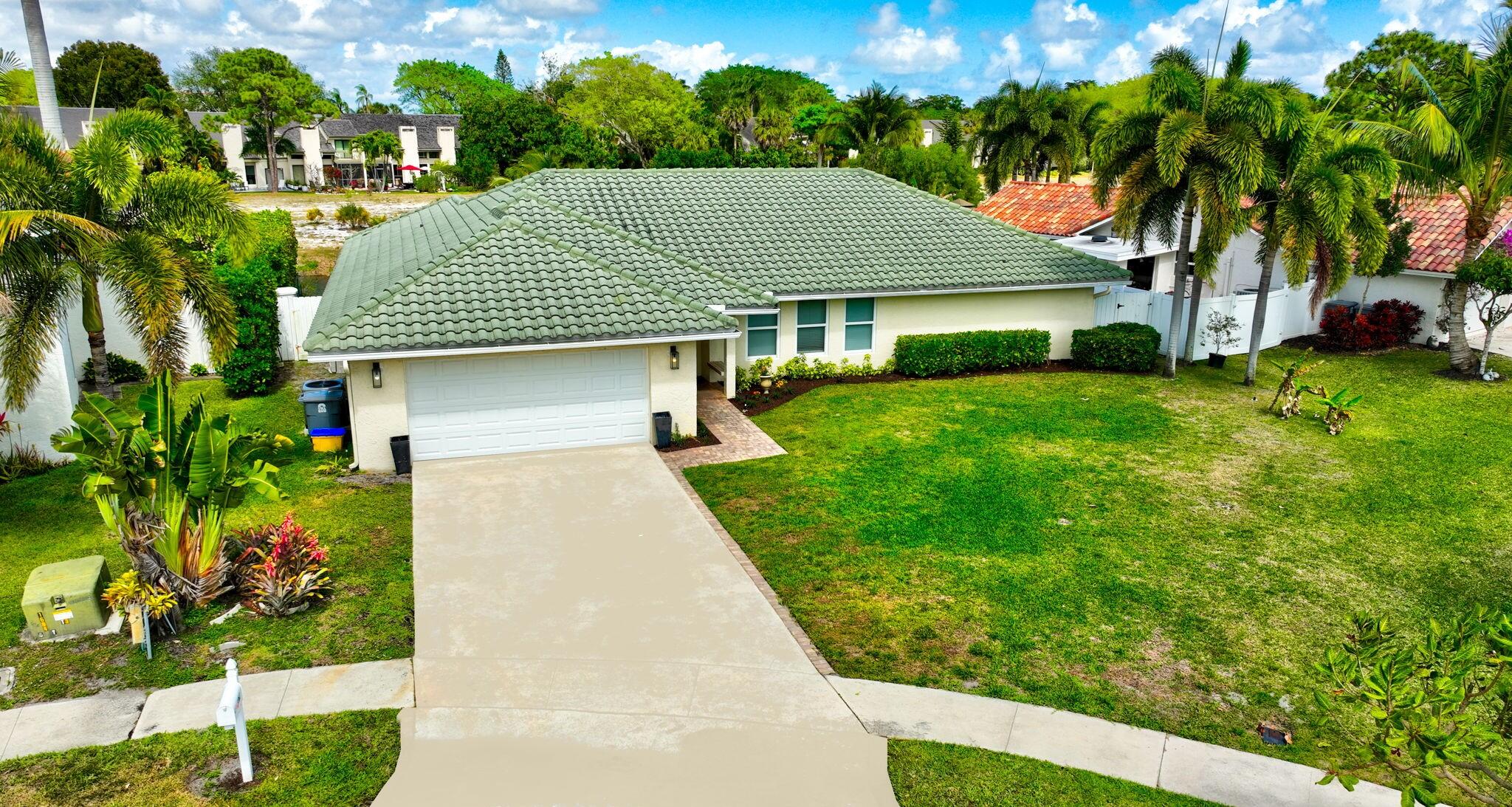 6063 Golf Vista Way Boca Raton, FL 33433 - Photo 1 of 52 a front view of a house with a garden