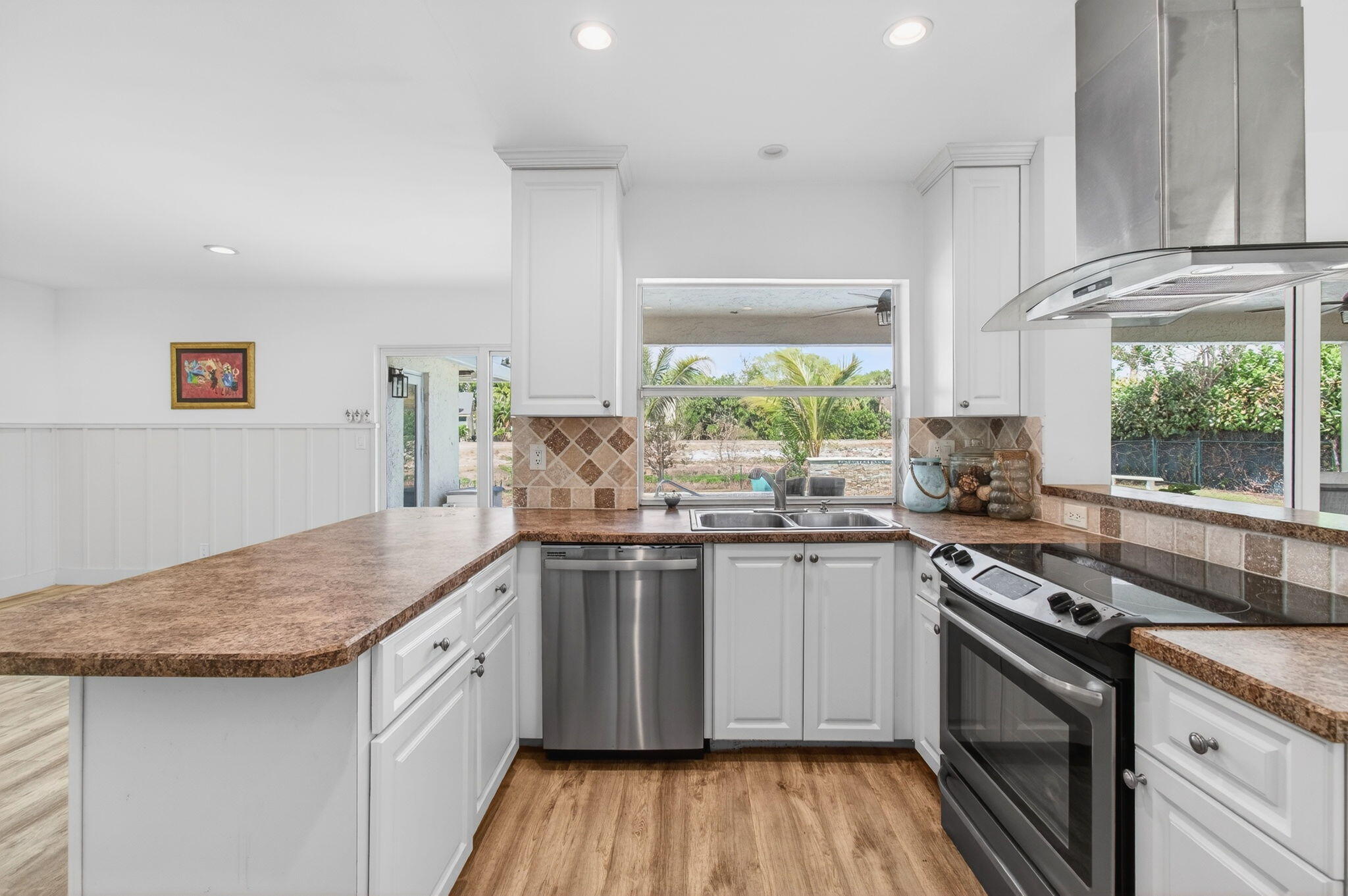 6063 Golf Vista Way Boca Raton, FL 33433 - Photo 16 of 52 a kitchen with stainless steel appliances granite countertop hardwood floor sink stove and wooden cabinets