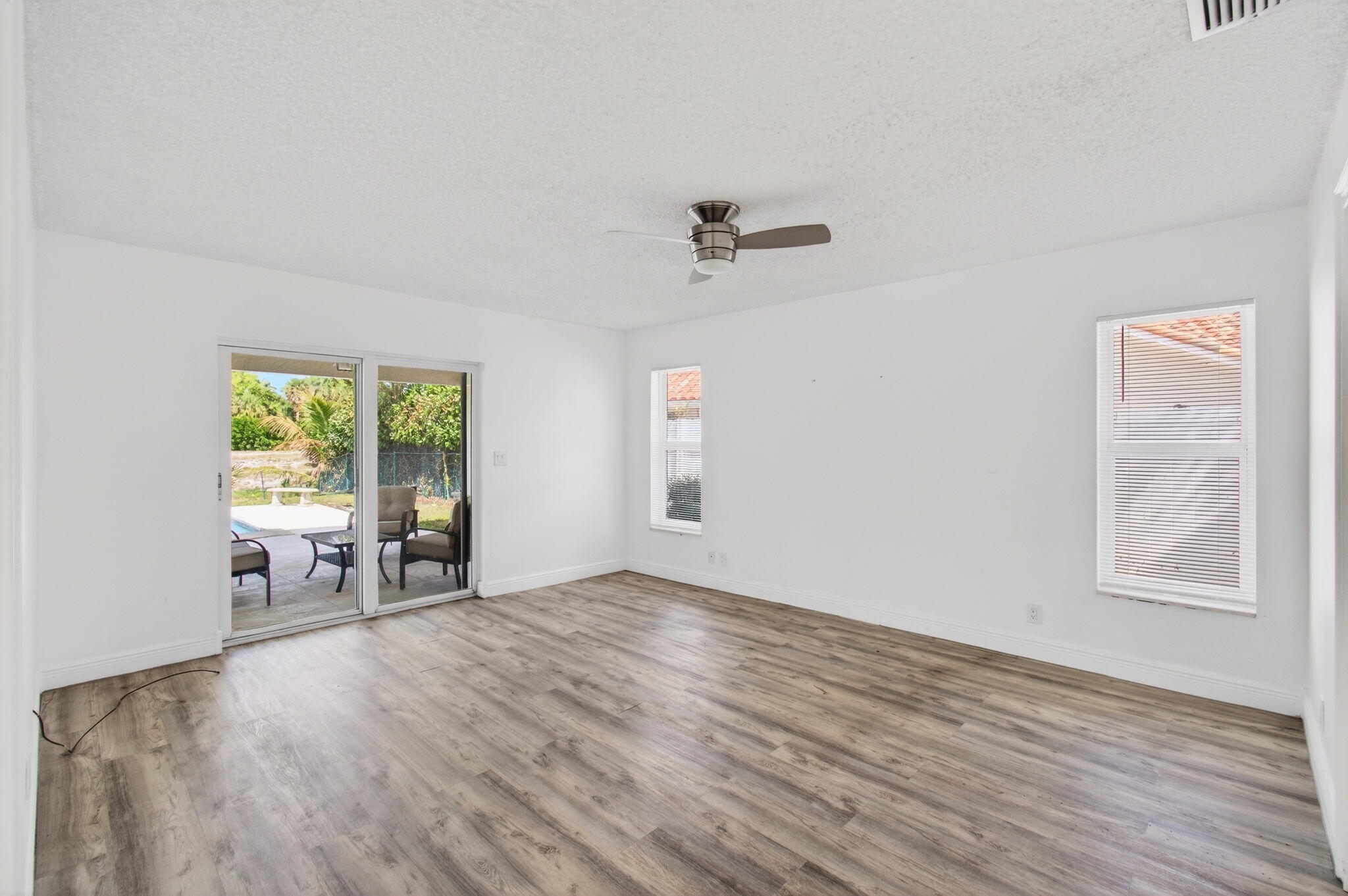 6063 Golf Vista Way Boca Raton, FL 33433 - Photo 21 of 52 wooden floor in an empty room with a window