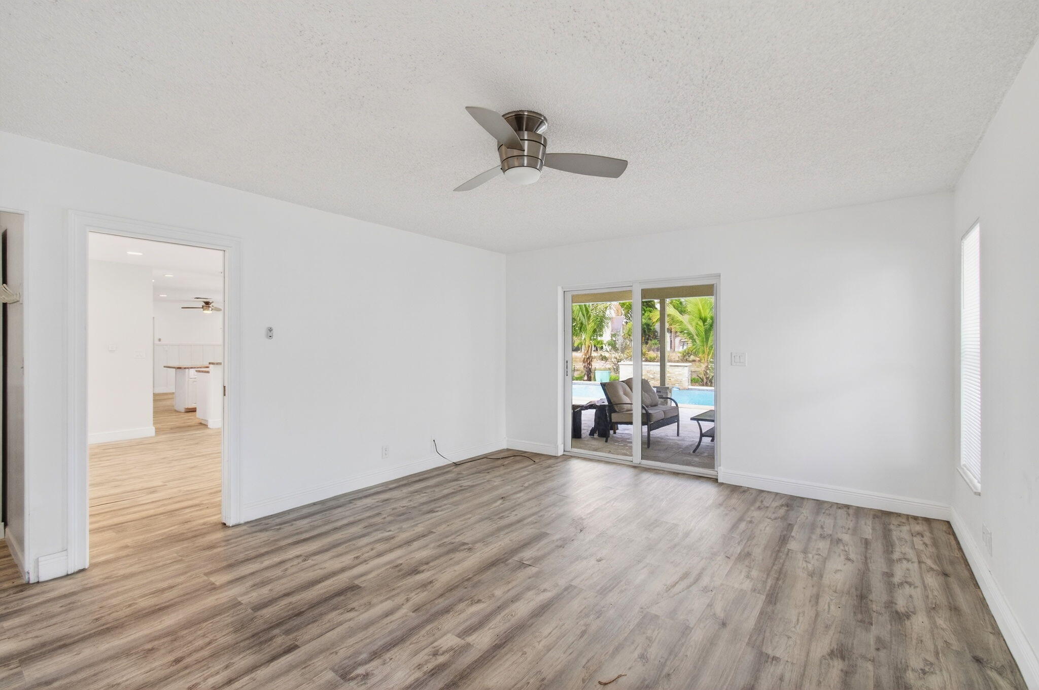 6063 Golf Vista Way Boca Raton, FL 33433 - Photo 22 of 52 a view of an empty room with a window and wooden floor