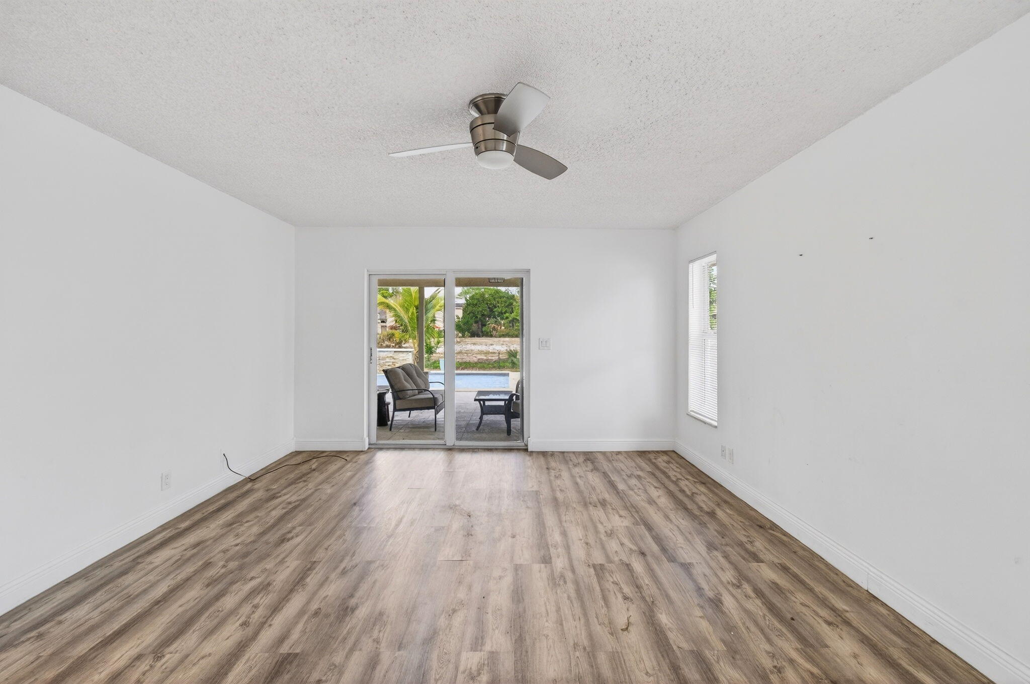 6063 Golf Vista Way Boca Raton, FL 33433 - Photo 23 of 52 a view of empty room with wooden floor and fan