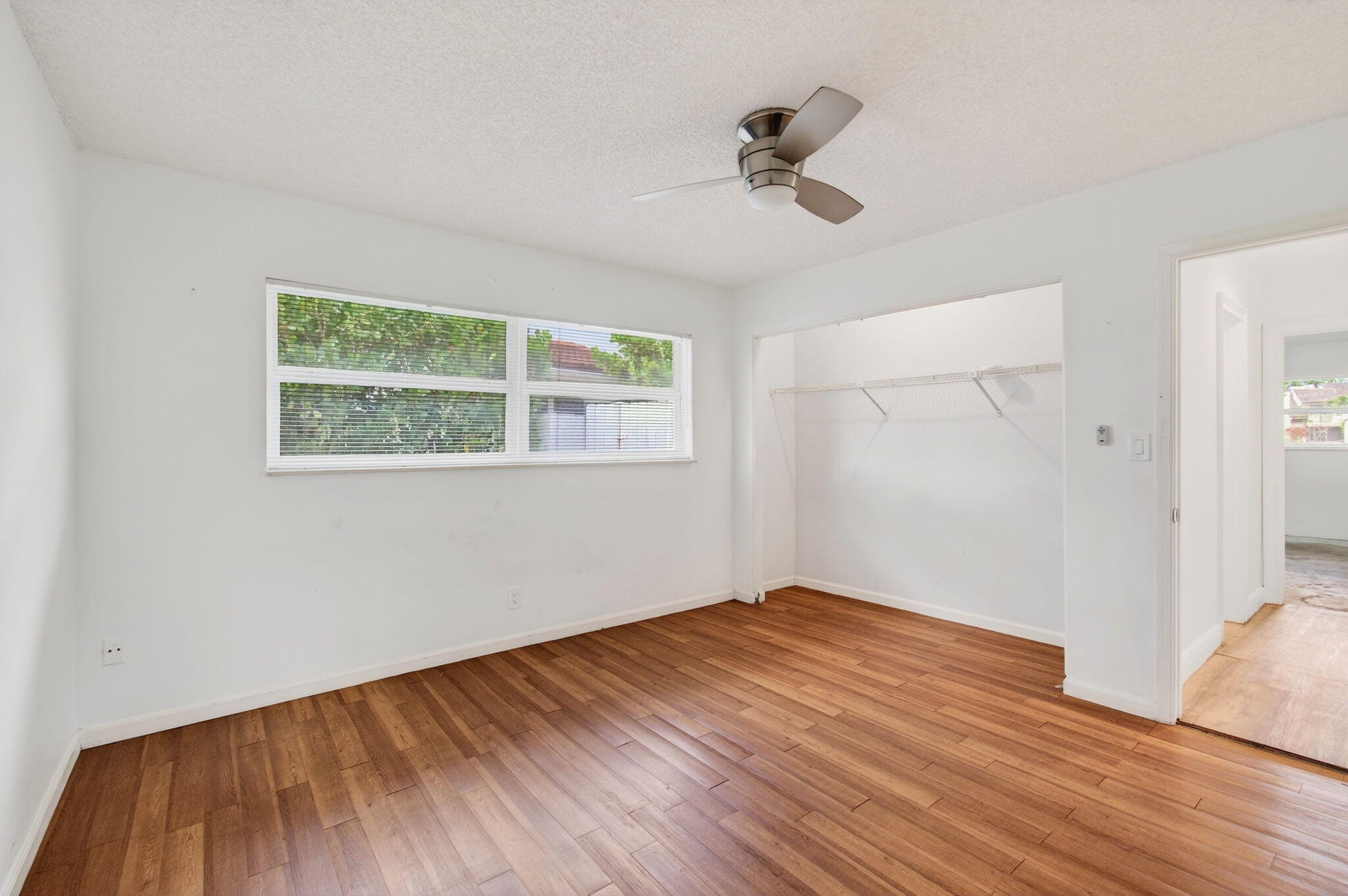 6063 Golf Vista Way Boca Raton, FL 33433 - Photo 31 of 52 a view of empty room with wooden floor and fan
