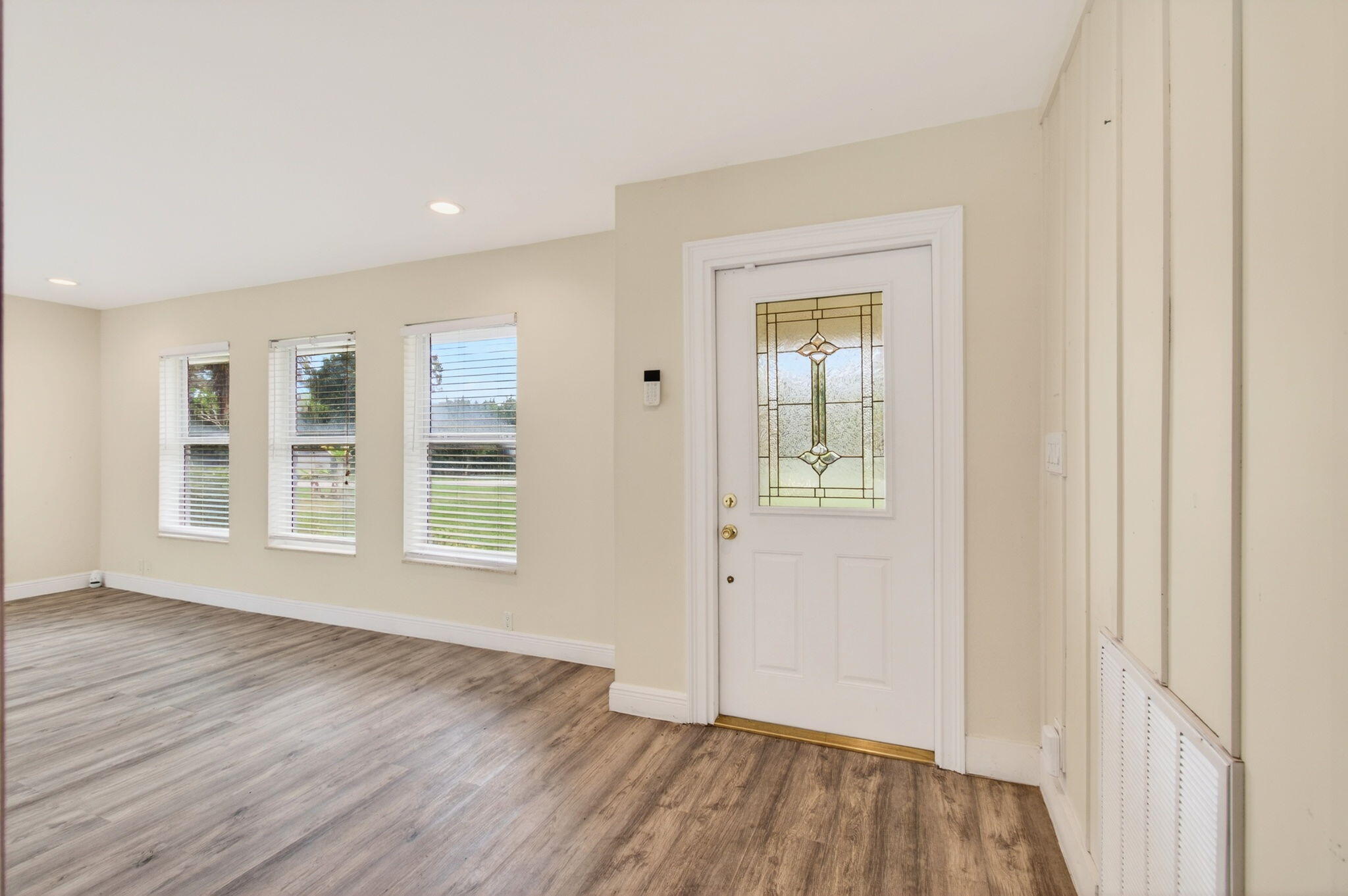 6063 Golf Vista Way Boca Raton, FL 33433 - Photo 7 of 52 an empty room with wooden floor and windows