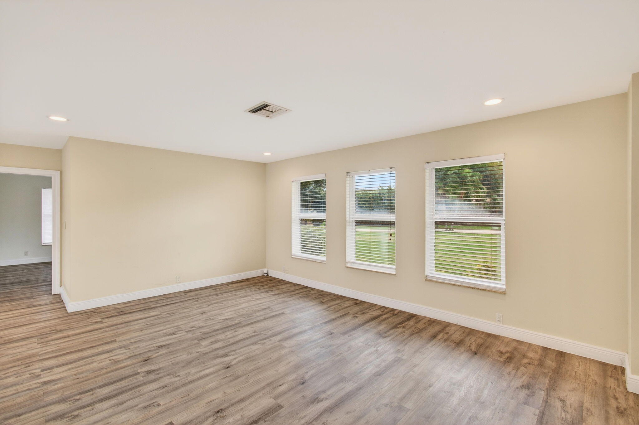 6063 Golf Vista Way Boca Raton, FL 33433 - Photo 9 of 52 a view of an empty room with wooden floor and a window