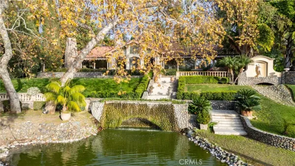 a front view of a house with a fountain and a tree