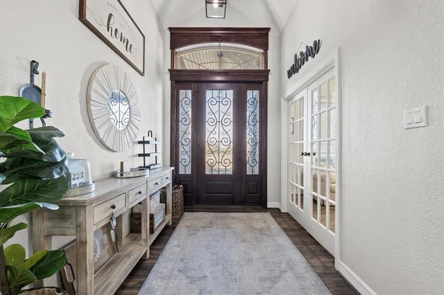 a view of an entryway door with a hallway and a front door