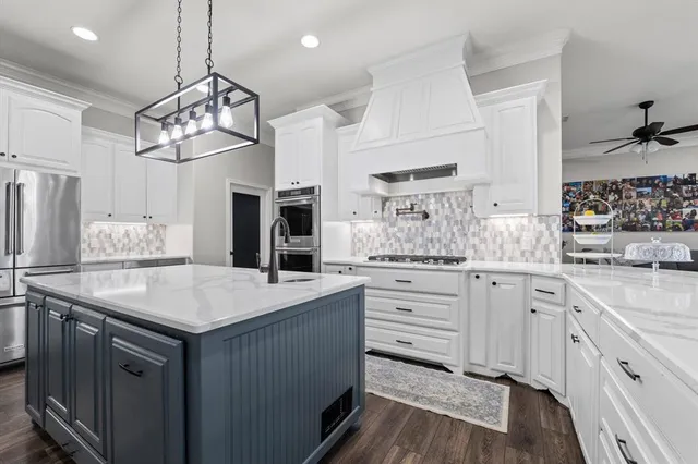 a kitchen with a sink dishwasher a stove a dining table and chairs with wooden floor