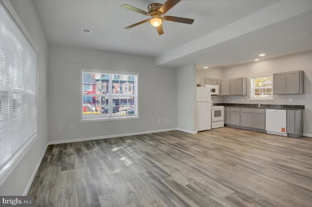 a view of a kitchen with a sink and dishwasher a refrigerator with wooden floor