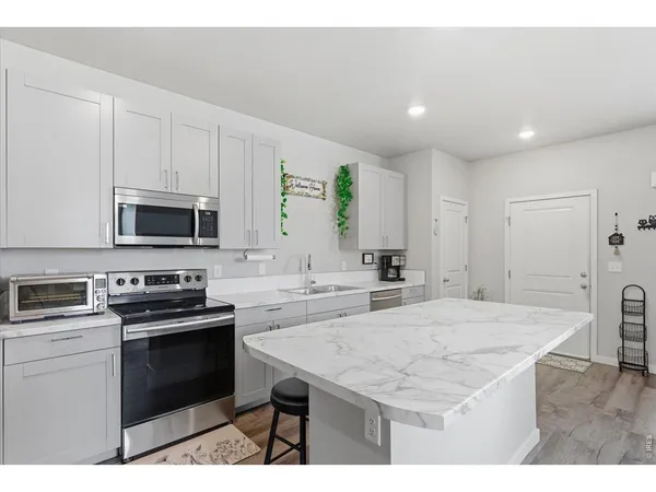 a kitchen with a sink a stove a refrigerator and cabinets