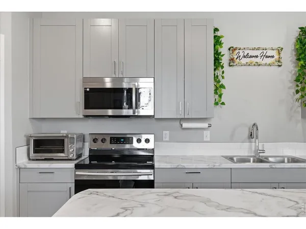a kitchen with a sink refrigerator and microwave