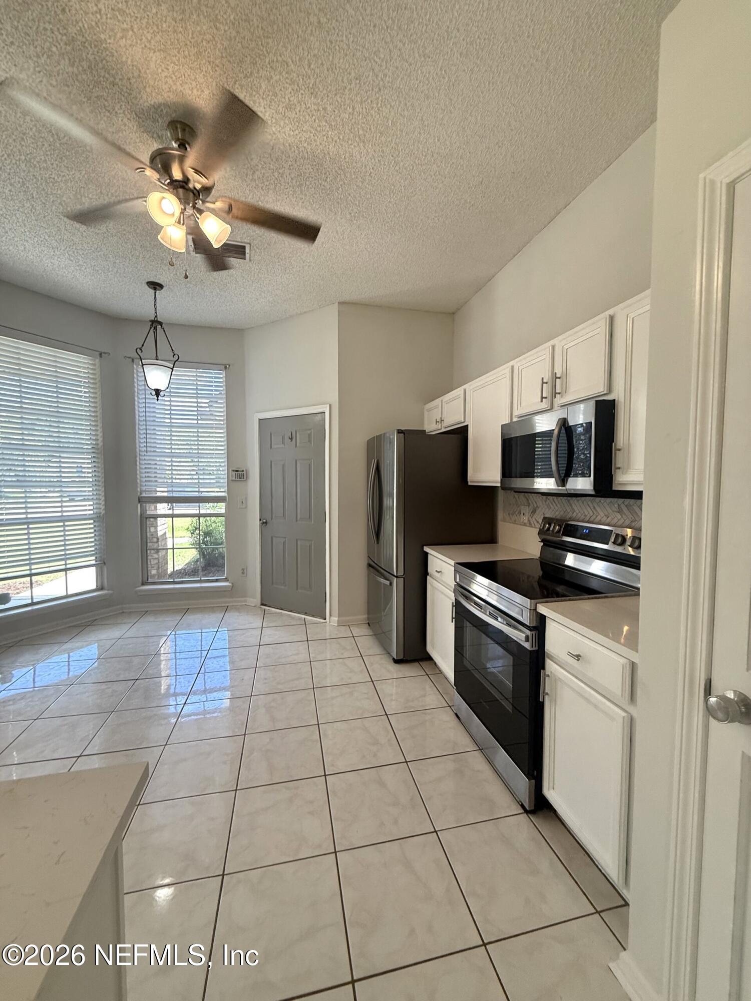 913 Mackinaw Trail St. Augustine, FL 32092 - Photo 27 of 65 a kitchen with stainless steel appliances granite countertop a refrigerator and a sink