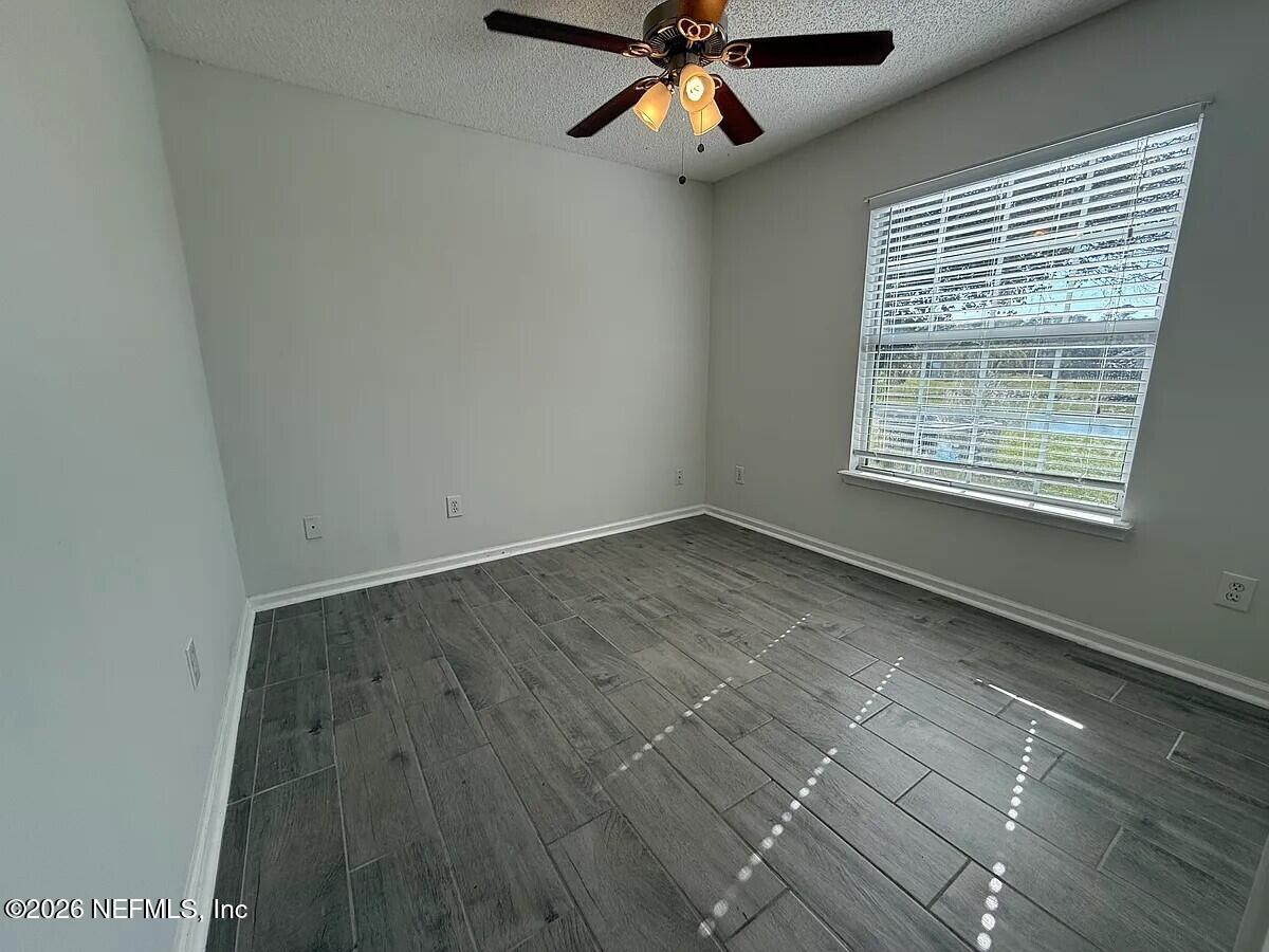 913 Mackinaw Trail St. Augustine, FL 32092 - Photo 39 of 65 a view of an empty room with wooden floor and a window