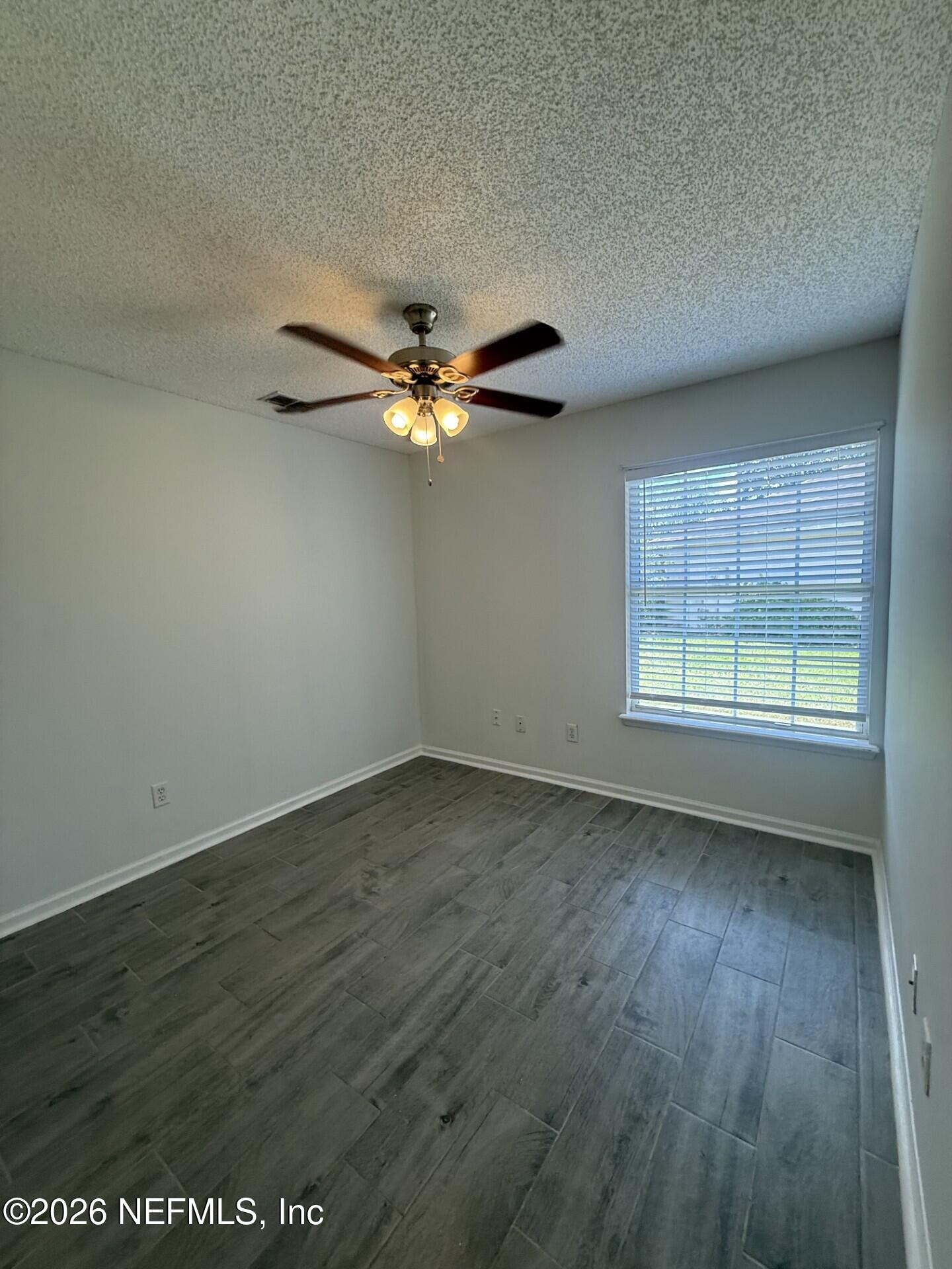 913 Mackinaw Trail St. Augustine, FL 32092 - Photo 45 of 65 an empty room with wooden floor fan and windows