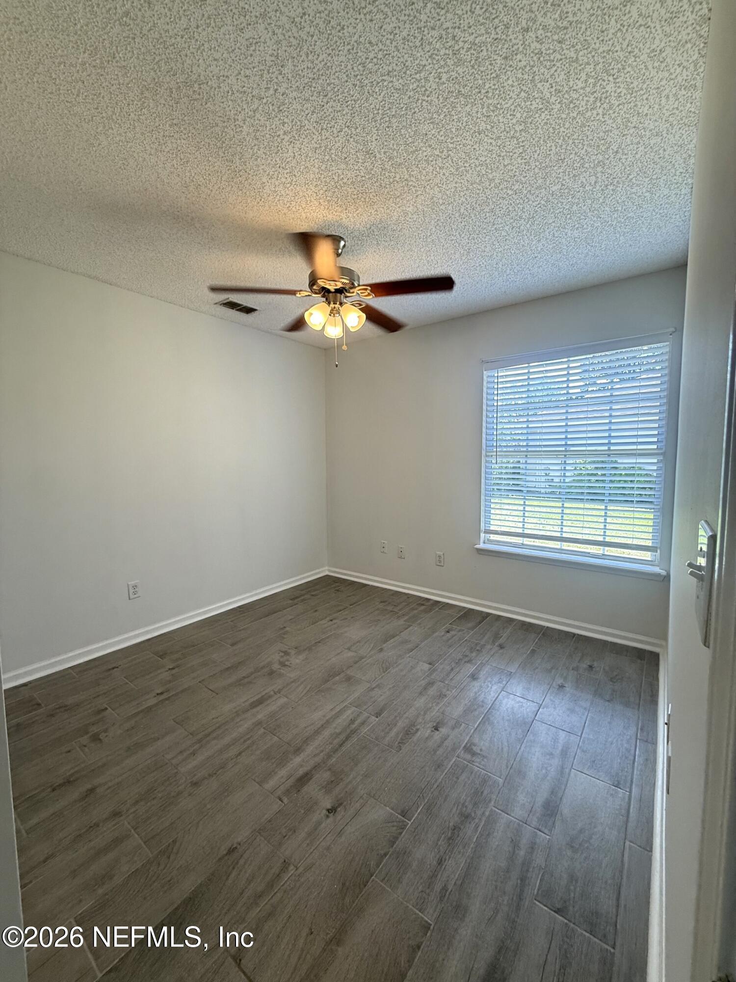 913 Mackinaw Trail St. Augustine, FL 32092 - Photo 46 of 65 an empty room with wooden floor fan and windows