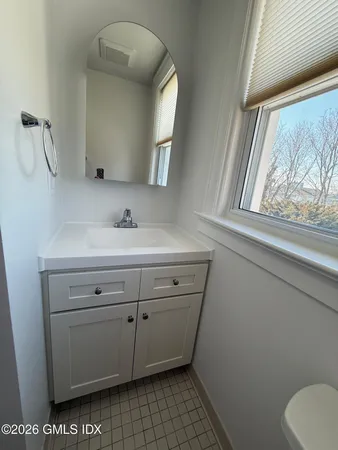 a bathroom with a sink a toilet and a mirror