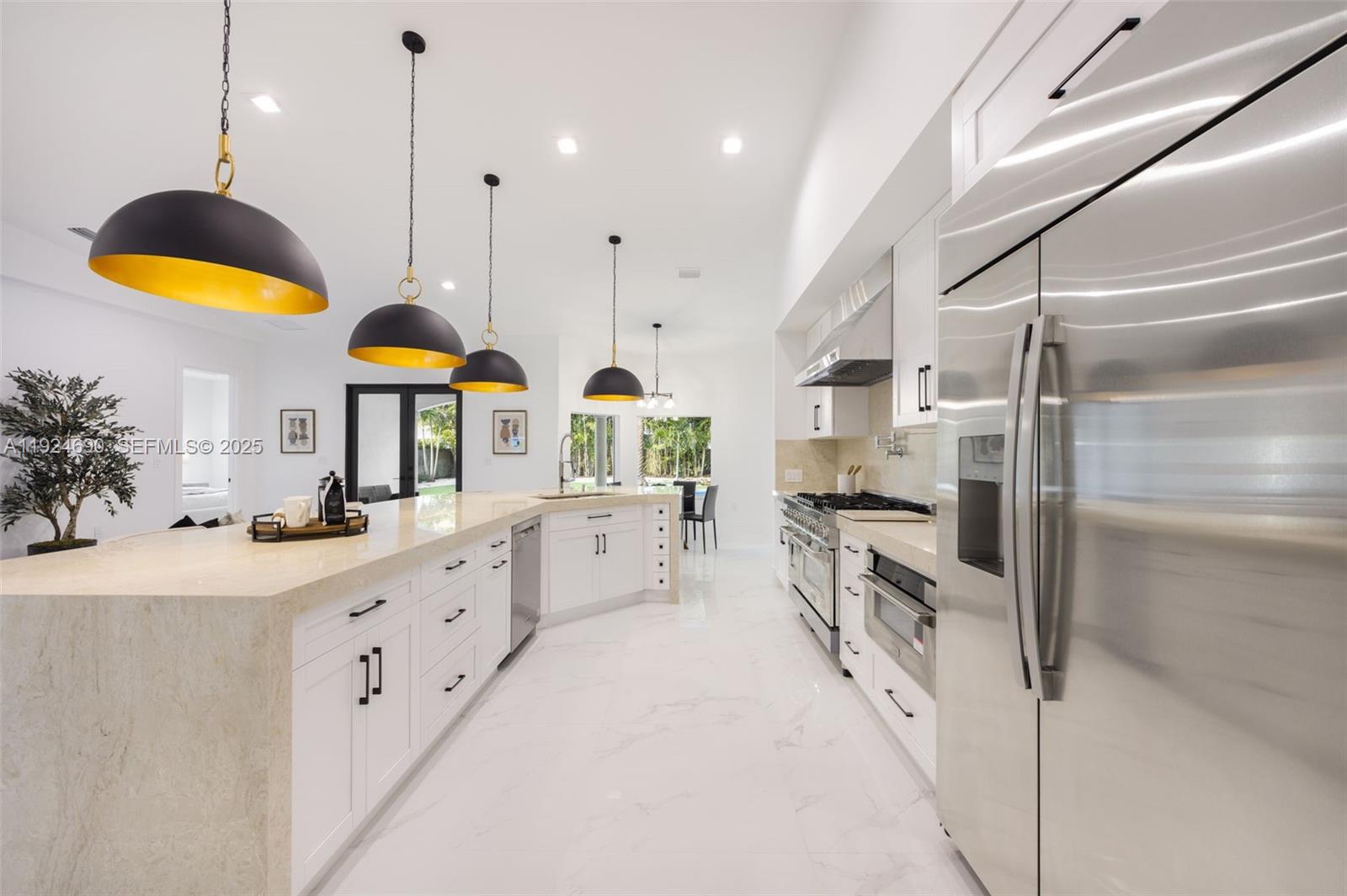 6845 Southwest 52nd Street Miami, FL 33155 - Photo 13 of 39 a kitchen with stainless steel appliances kitchen island granite countertop a stove a sink a oven and a refrigerator