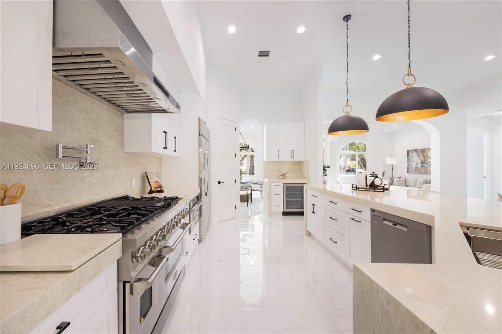 6845 Southwest 52nd Street Miami, FL 33155 - Photo 15 of 39 a kitchen with stainless steel appliances kitchen island a stove a sink a refrigerator and chairs