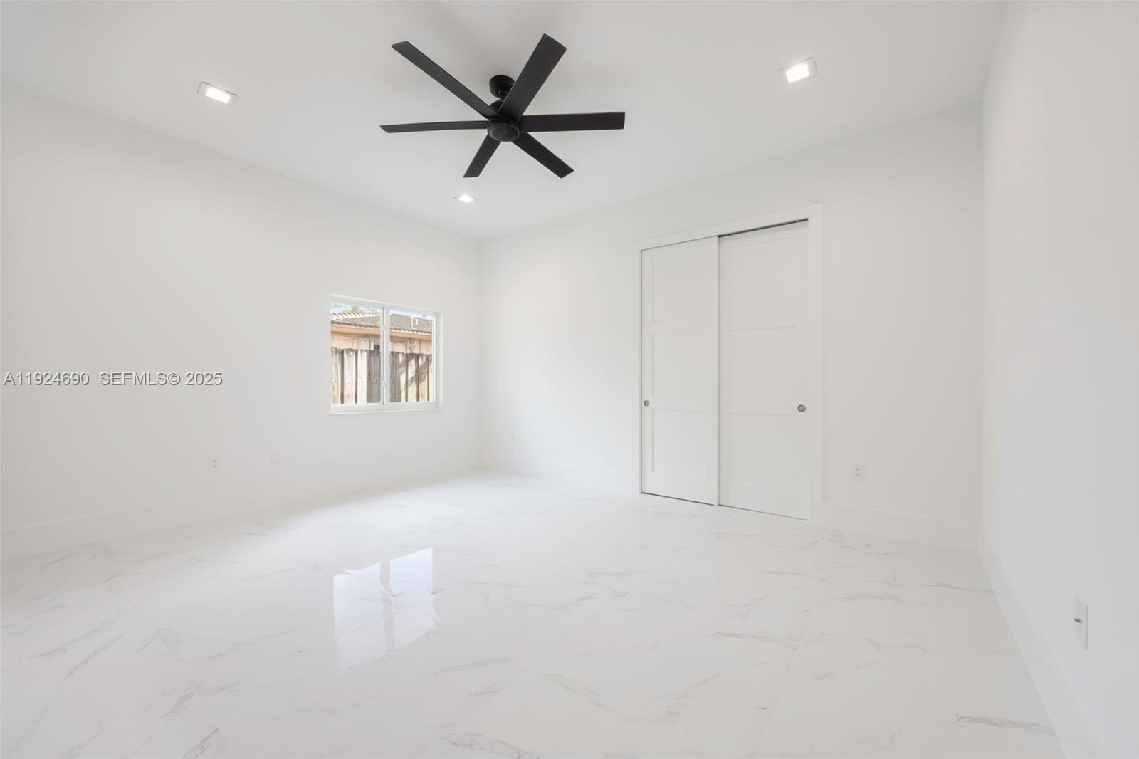 6845 Southwest 52nd Street Miami, FL 33155 - Photo 23 of 39 an empty room with a ceiling fan and windows