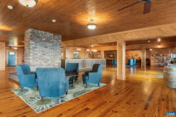 a living room with couches and kitchen view with wooden floor