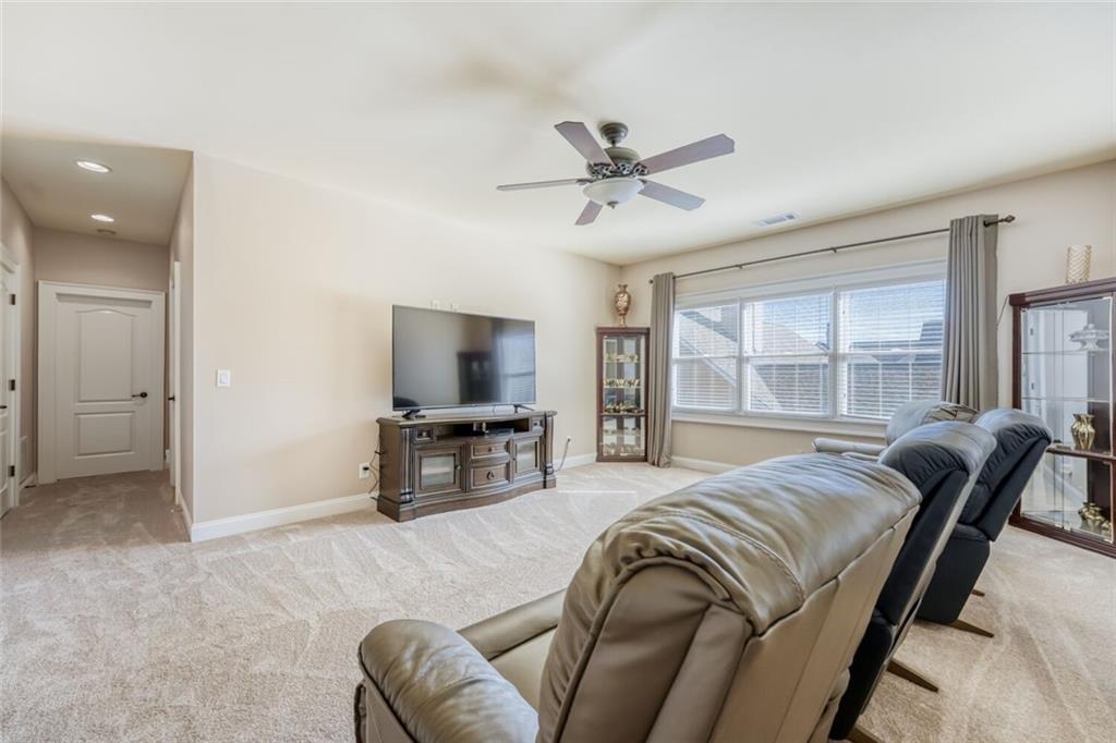 2380 Muskogee Lane Braselton, GA 30517 - Photo 7 of 30 a living room with furniture a flat screen tv and a large window