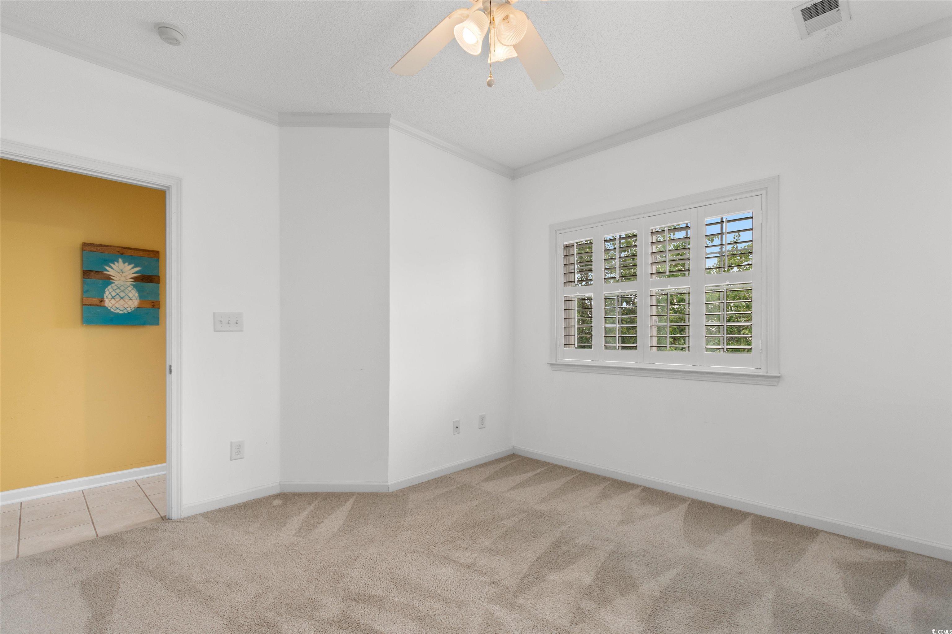1529 Lanterns Rest Road, Unit 201 Myrtle Beach, SC 29579 - Photo 23 of 34 Spare room featuring carpet floors, crown molding, ceiling fan, baseboards, and a smoke detector