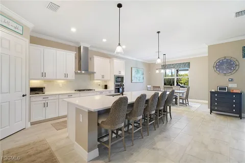 a large kitchen with cabinets chairs and counter space