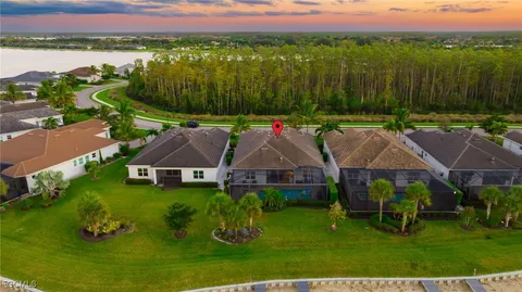 an aerial view of residential houses with outdoor space and trees