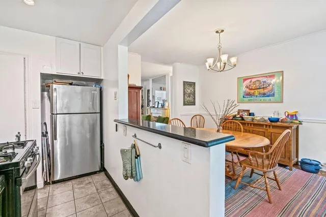 a kitchen with stainless steel appliances granite countertop a refrigerator a sink a stove and white cabinets