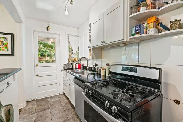 a kitchen with white cabinets and appliances