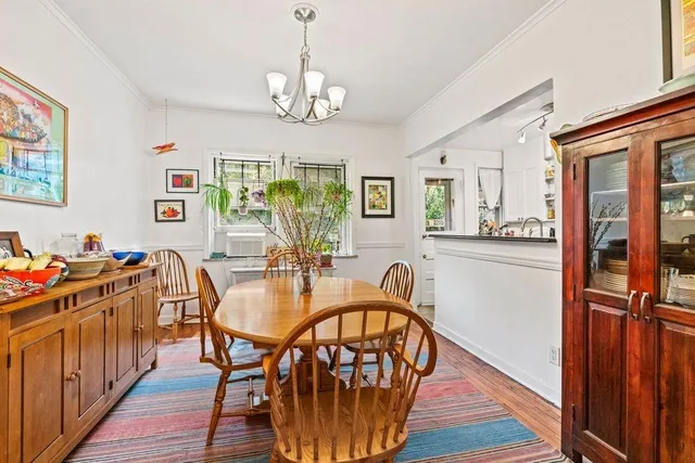 a view of a dining room with furniture a chandelier and wooden floor