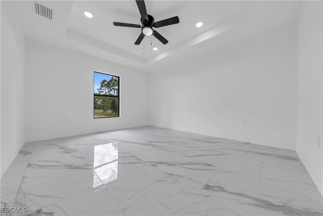 7602 18th Place LaBelle, FL 33935 - Photo 12 of 30 en empty room with windows and ceiling fan