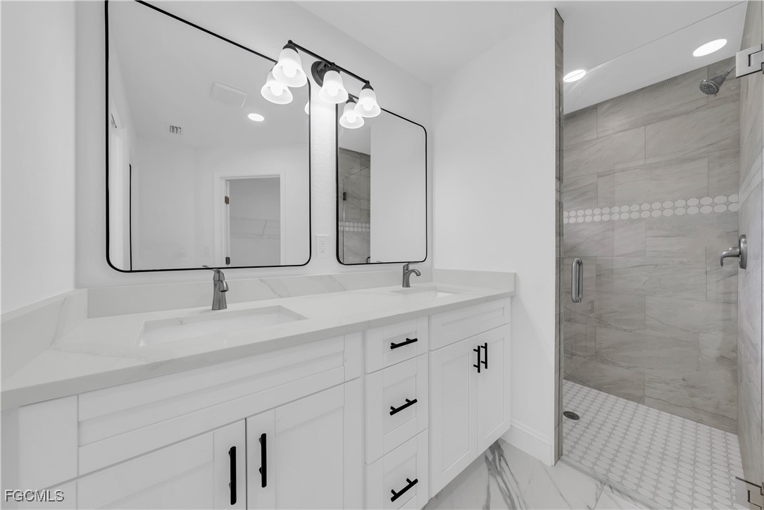 7602 18th Place LaBelle, FL 33935 - Photo 16 of 30 a bathroom with a double vanity sink mirror and shower