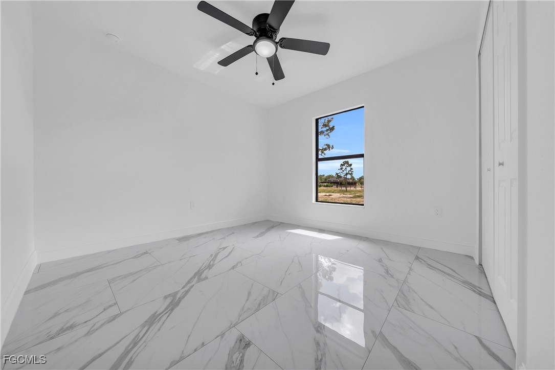 7602 18th Place LaBelle, FL 33935 - Photo 19 of 30 an empty room with fan and windows