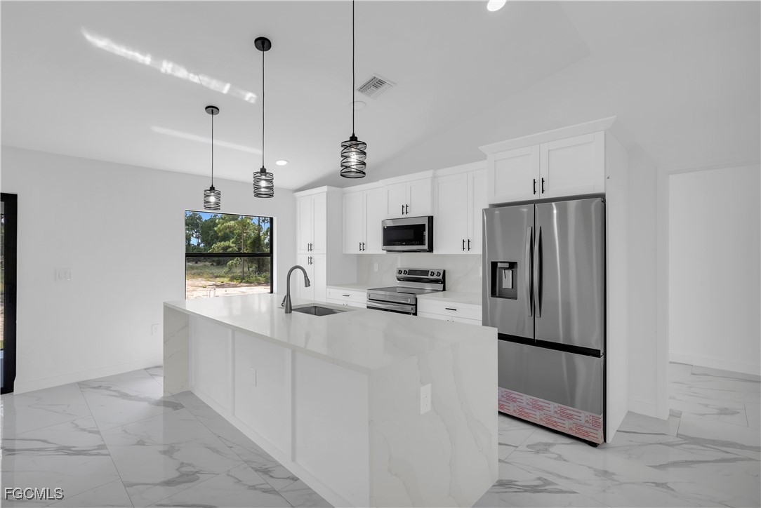 7602 18th Place LaBelle, FL 33935 - Photo 9 of 30 a kitchen with stainless steel appliances a refrigerator sink and microwave