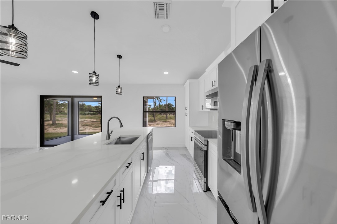 7602 18th Place LaBelle, FL 33935 - Photo 10 of 30 a kitchen with stainless steel appliances granite countertop a refrigerator and a sink