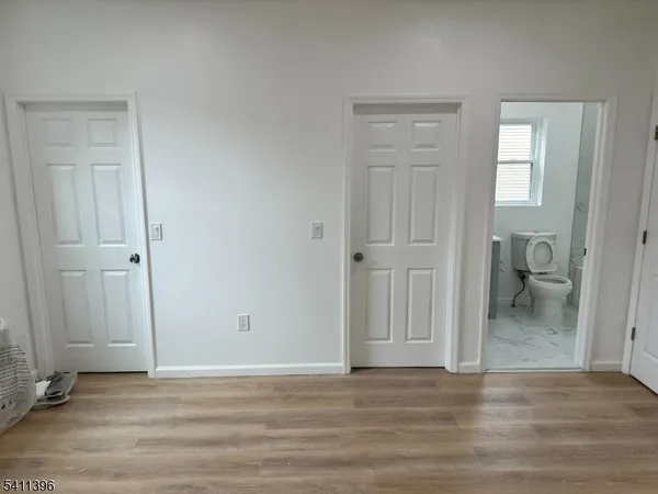 a view of a livingroom with wooden floor and a bathroom
