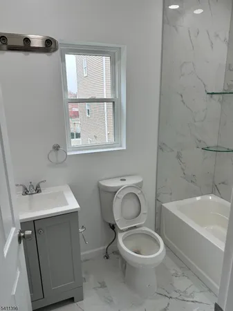 a bathroom with a sink toilet and window