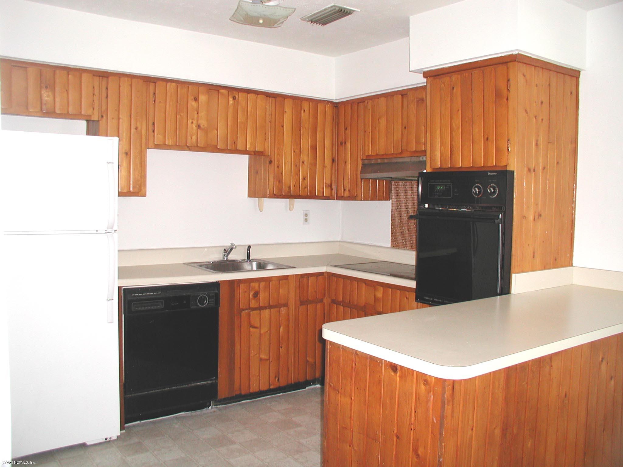 4450 Vinton Road Jacksonville, FL 32207 - Photo 2 of 5 a kitchen with stainless steel appliances a refrigerator a sink and wooden cabinets