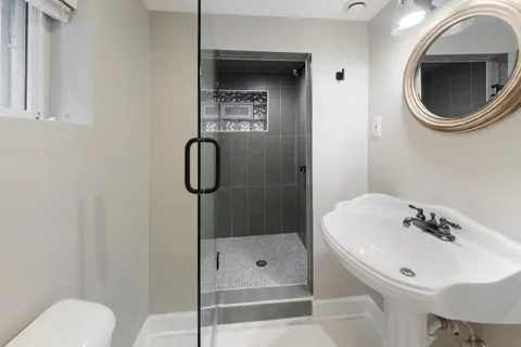 a bathroom with a sink a toilet and shower