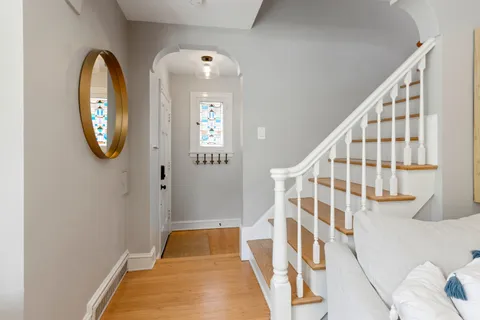 a view of a hallway with entryway wooden floor and front door