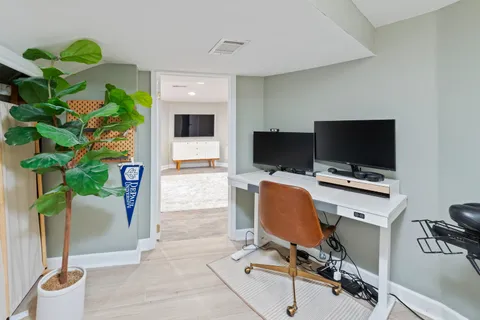 a view of a workspace with furniture and a flat screen tv