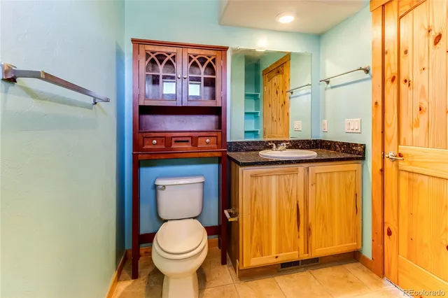 a walk in closet with wooden floor