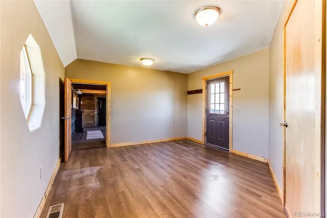 a view of a hall with wooden floor and windows