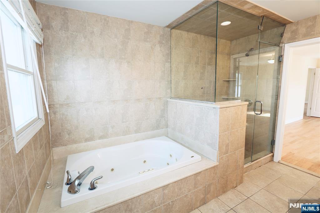23 Main Avenue Wallington, NJ 07057 - Photo 19 of 29 a bathroom with a tub a sink and a shower