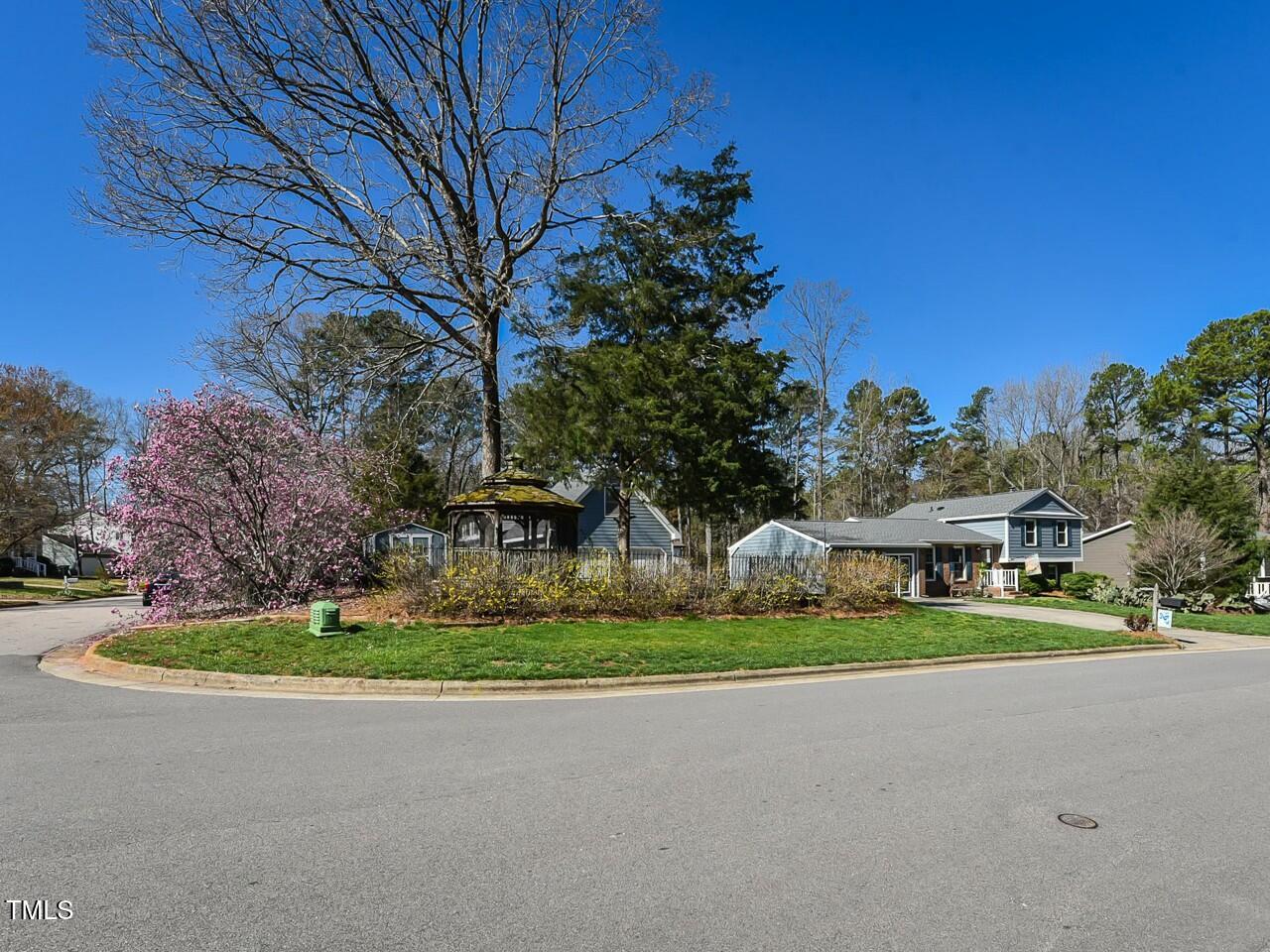 310 Electra Drive Cary, NC 27513 - Photo 3 of 45 a front view of a house with a garden and trees