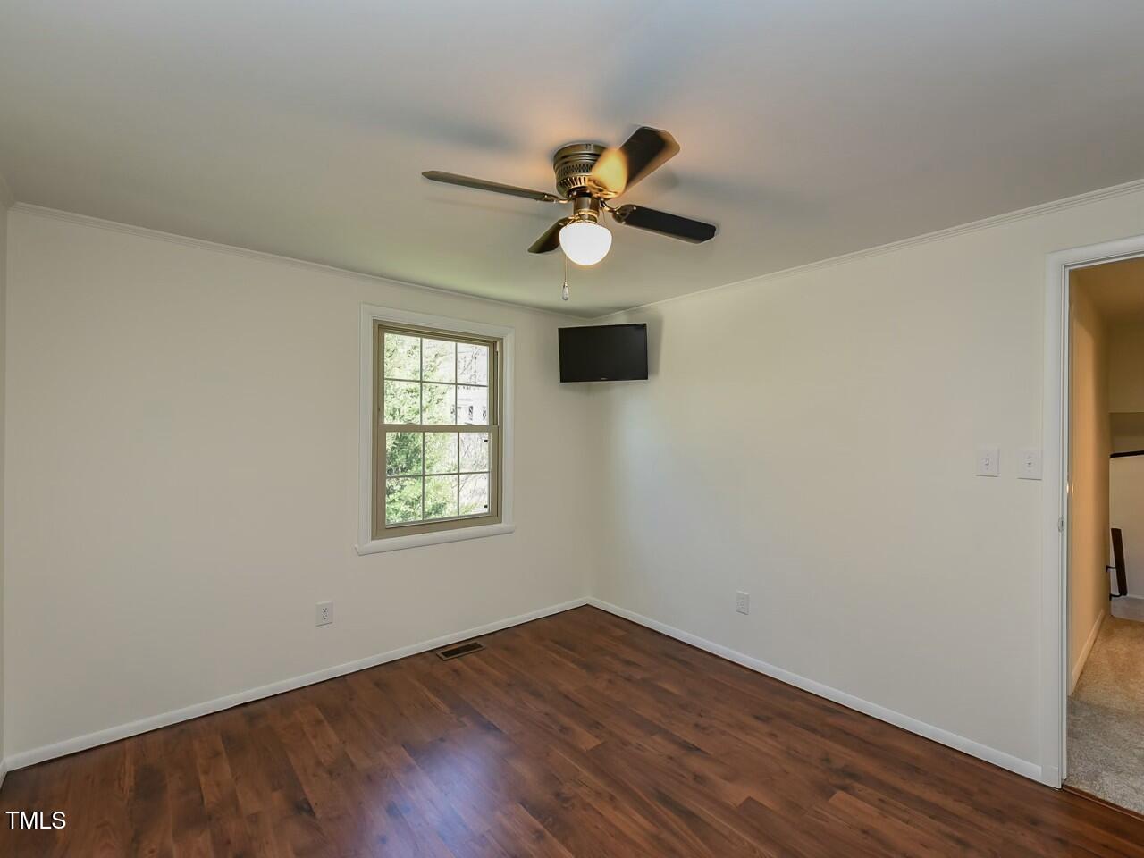 310 Electra Drive Cary, NC 27513 - Photo 32 of 45 a view of an empty room with wooden floor and a window